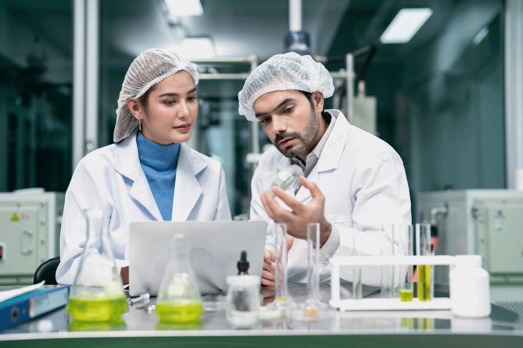 researchers in lab coats analyzing data on a laptop for a study on the benefits of medical cannabis for PTSD.