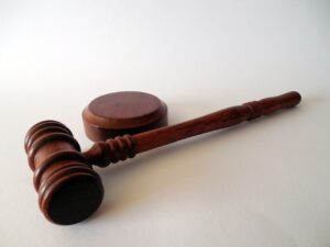 Image of wooden gavel and box on white background, representing legal implications of medical cannabis laws in Texas.